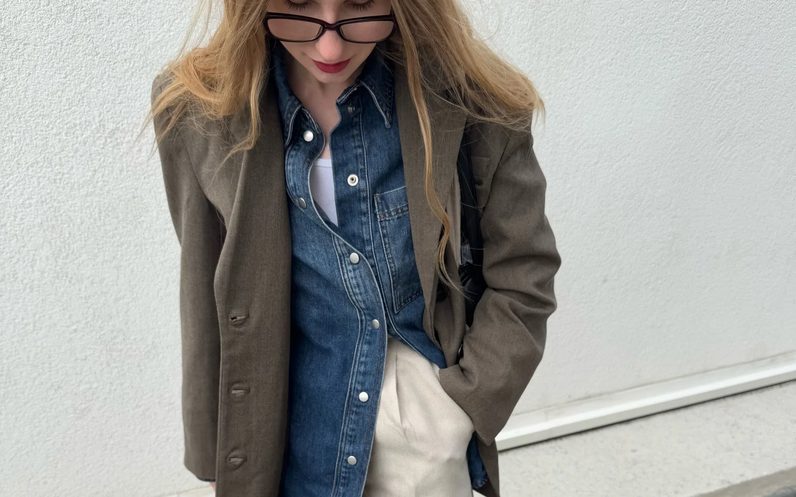 Person wearing a removable blazer over a denim shirt for changing weather