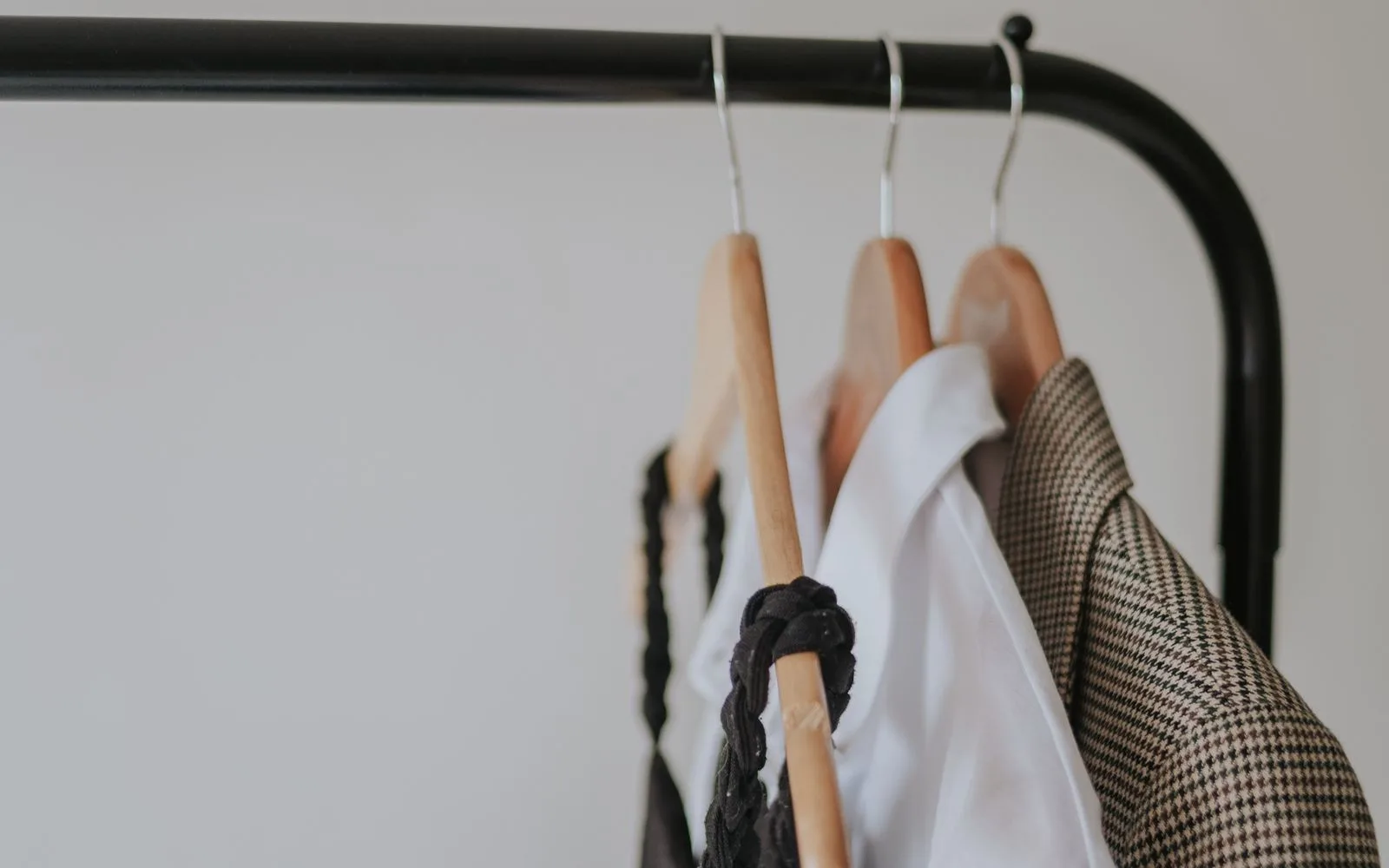 Minimal clothing rack displaying casual garments in neutral colours